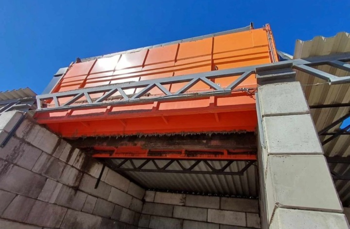Trommel Ø 200 cm x 7 m en poste fixe – DMB Machine Trommel Ø 200 cm x 7 m installé en poste fixe sur piliers béton, vue en contre-plongée de la sortie des fines sous le tambour, DMB Machine